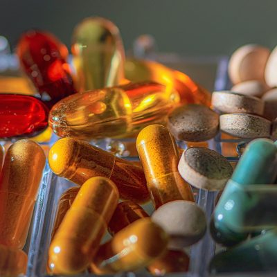 编辑用红笔在打印出来的页面草稿上圈出需要补充说明的段落，桌面上散落着不同颜色的荧光笔